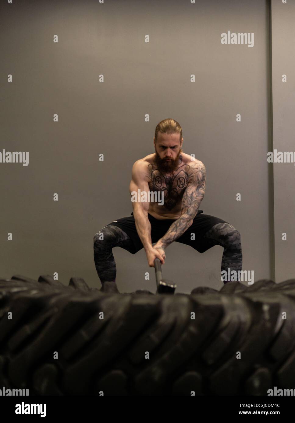 Sledgehammer camion roue roue pneu femme remplacer jeune Hammer gym, pour la concentration d'équipement de l'homme de l'entraînement musculaire, homme adulte Banque D'Images