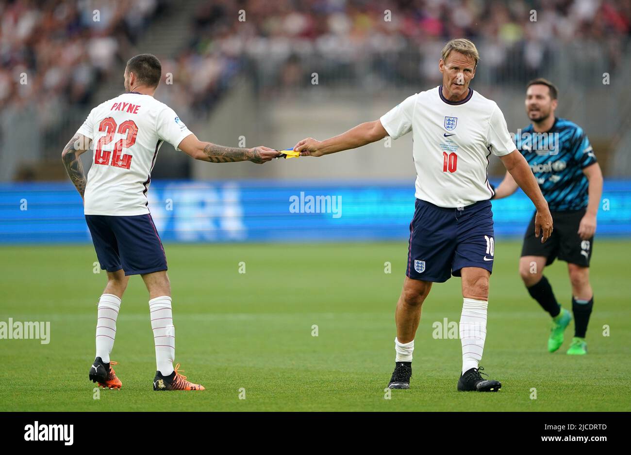 Teddy Sheringham (à droite), de l'Angleterre, passe le brassard du capitaine au coéquipier Liam Payne lors du match de football Aid for UNICEF au London Stadium, à Londres. Date de la photo: Dimanche 12 juin 2022. Banque D'Images