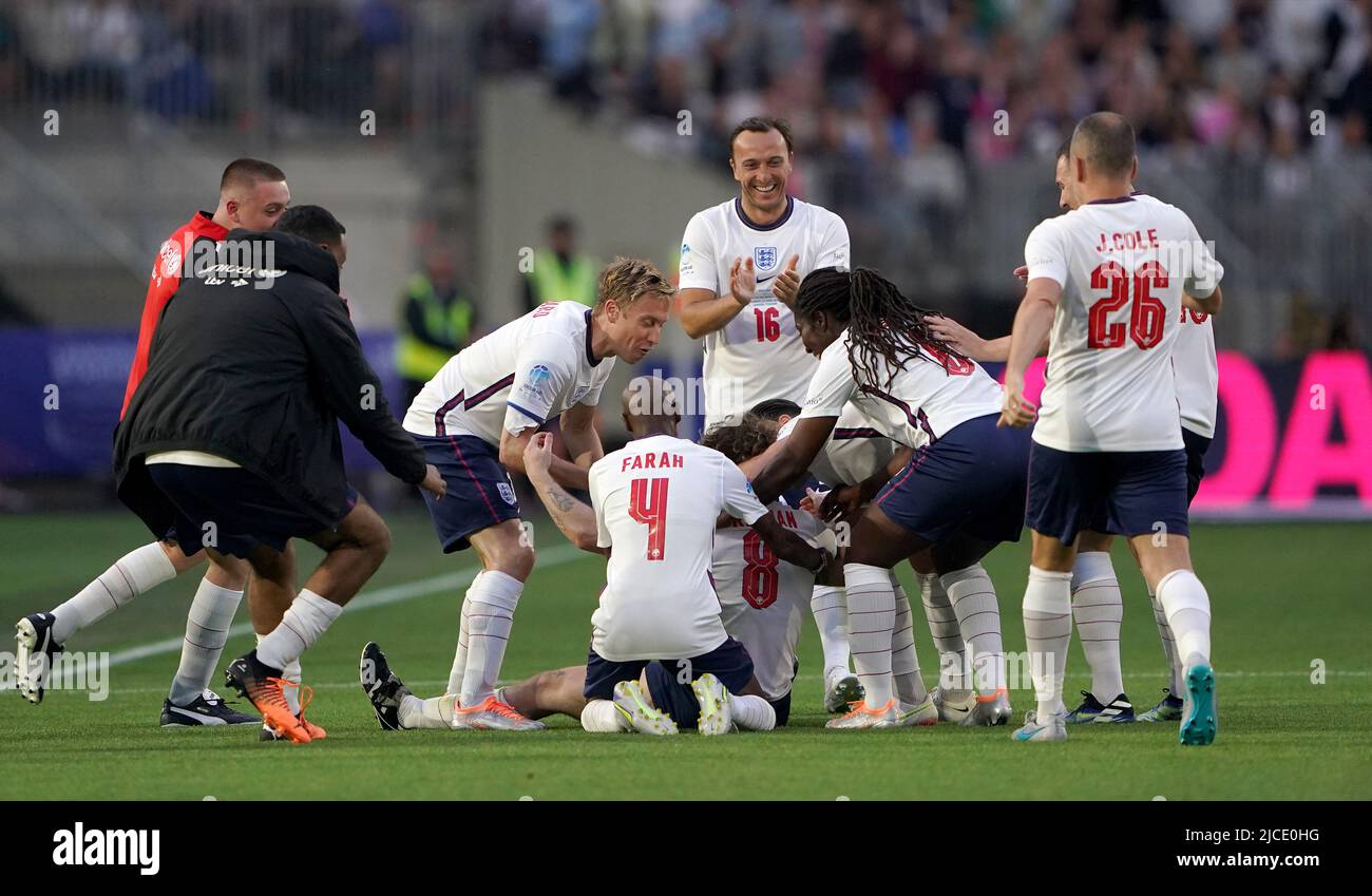 Tom Grennan, en Angleterre, est attrapé par des coéquipiers après avoir marquant le deuxième but de leur partie lors du match de football Aid for UNICEF au stade de Londres, à Londres. Date de la photo: Dimanche 12 juin 2022. Banque D'Images