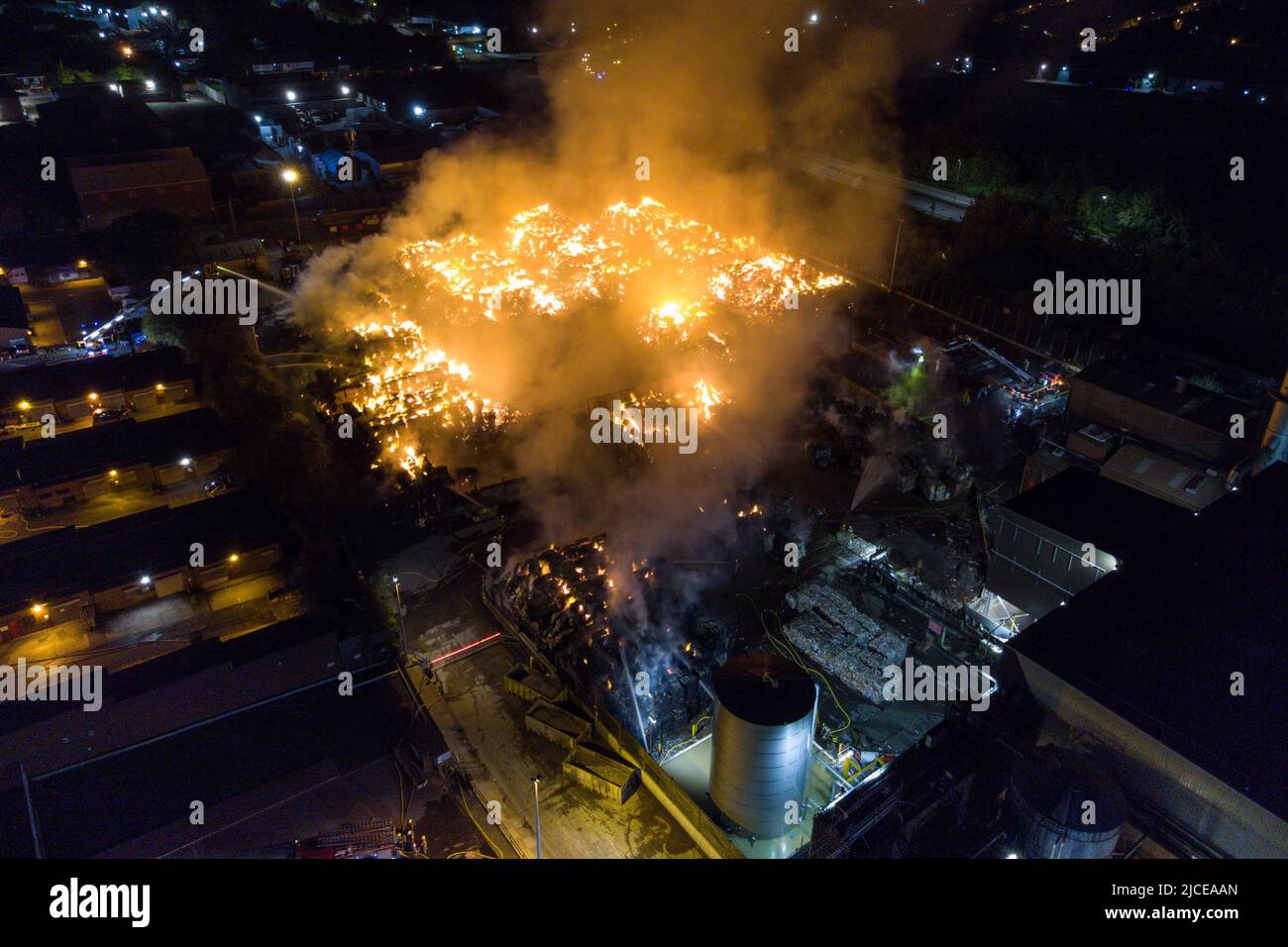 Nechells, Birmingham, Angleterre, 12 juin 2022. Plus de 100 pompiers s'attaquent à un énorme enfer au complexe de recyclage Smurfit Kappa à Nechells, Birmingham. Les services d'incendie des West Midlands ont déployé 20 appareils, dont deux plates-formes hydrauliques aériennes, plusieurs pompiers, une unité de pompage d'eau à grand volume. L'incident concerne 8000 tonnes de balles de papier et de carton en feu dans un entrepôt. Crédit : arrêtez Press Media/Alamy Live News Banque D'Images