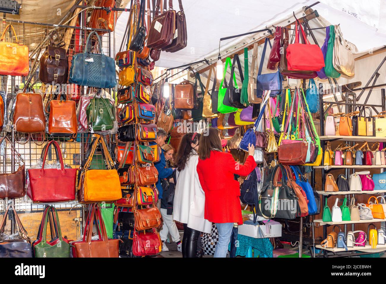 Les femmes magasinent pour des sacs à main en cuir dans le nouveau marché (Mercato Nuovo) Florence (Firenze), région Toscane, Italie Banque D'Images