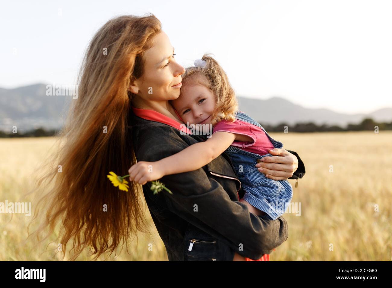 Portrait d'une jeune mère heureuse et de sa belle fille jouant et riant dans un champ de blé . Concept de liberté. Banque D'Images