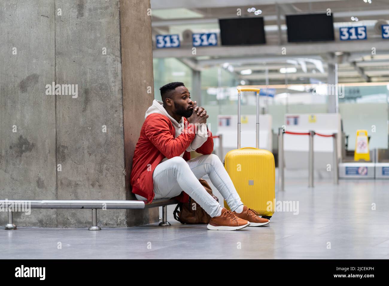 Un touriste noir fatigué sur une longue liaison de nuit à l'aéroport, attendant que l'avion soit assis dans le terminal Banque D'Images