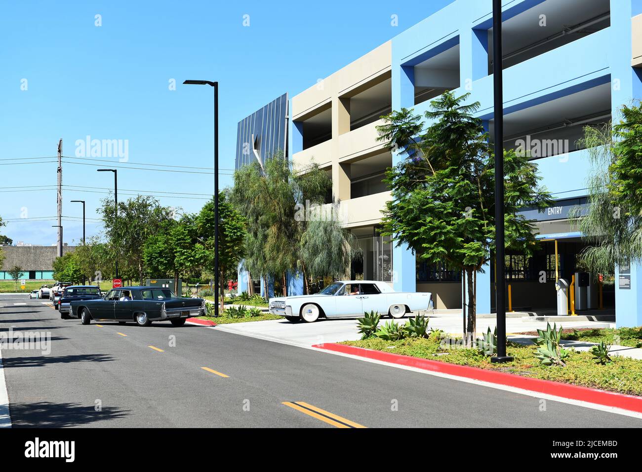 TUSTIN, CALIFORNIE - 12 JUIN 2022 : voitures classiques Lincoln Contintntal laissant la structure de stationnement au vol de Tustin Legacy. Banque D'Images