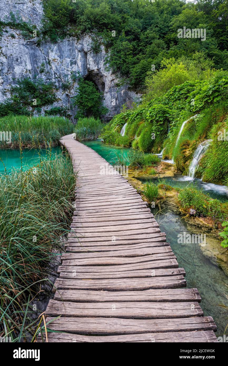 Plitvice, Croatie - passerelle en bois dans le parc national des lacs de Plitvice lors d'une journée d'été lumineuse avec de l'eau turquoise cristalline, un feuillage d'été vert et Banque D'Images