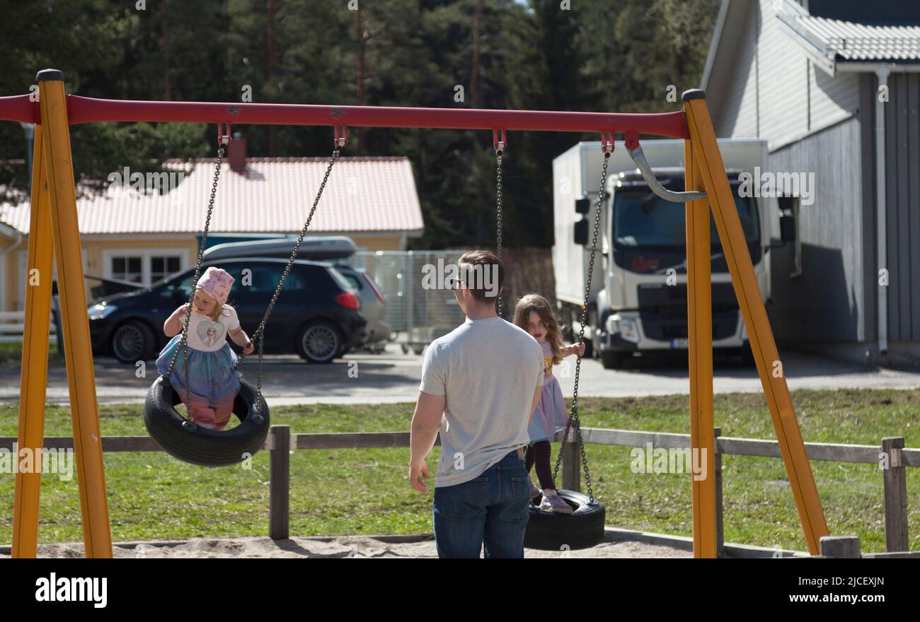 Umea, Norrland Suède - 20 mai 2022: Un père balance ses deux filles Banque D'Images