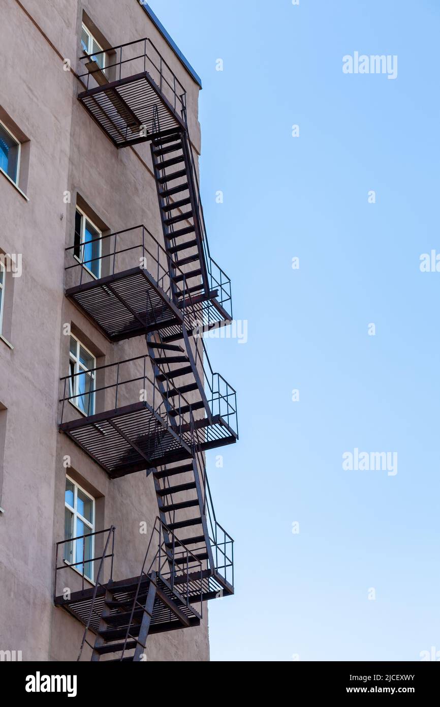 Silhouette d'une évasion de feu sur un bâtiment de haute élévation contre un ciel bleu avec des nuages. Certains escaliers sont cassés. Il y a de l'espace libre pour le texte Banque D'Images