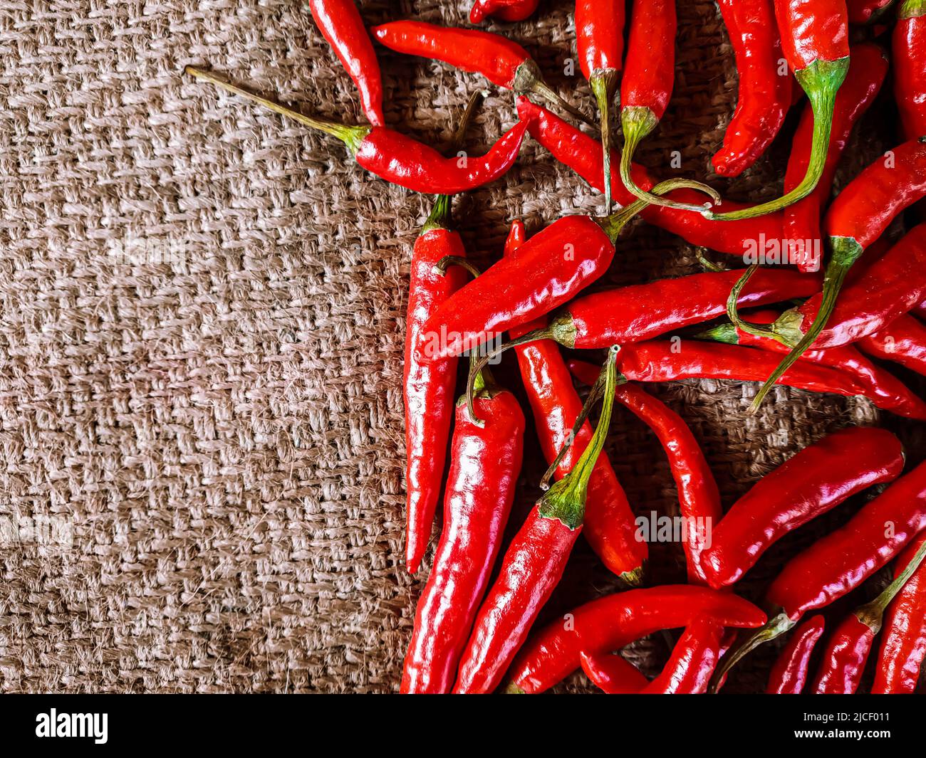 Piments rouges frais sur fond de tissu vintage. Piment rouge frais isolé. Banque D'Images