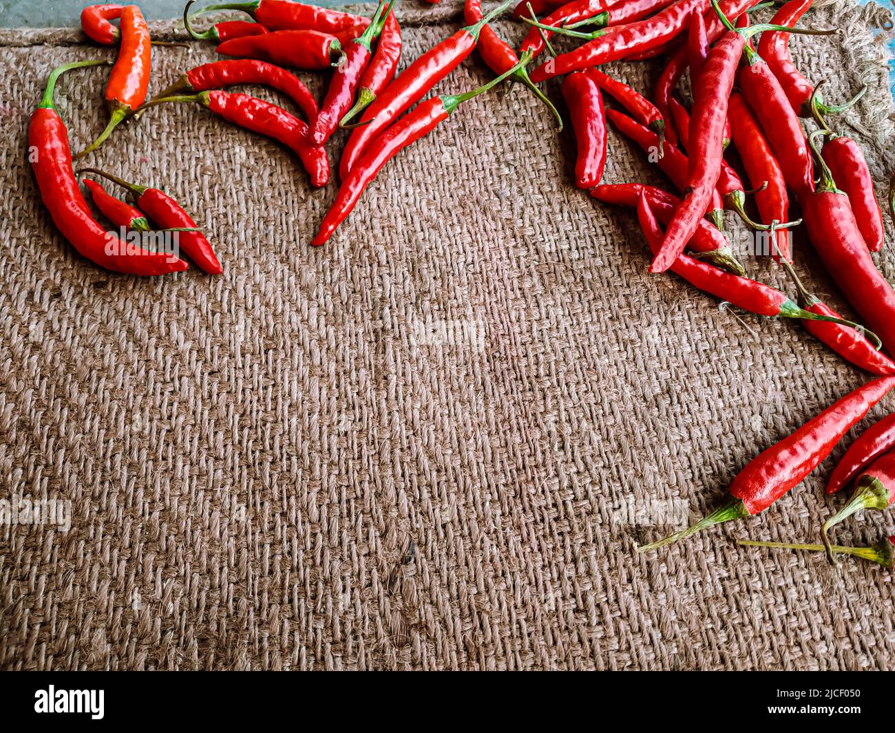 Piments rouges frais sur fond de tissu vintage. Piment rouge frais isolé. Banque D'Images