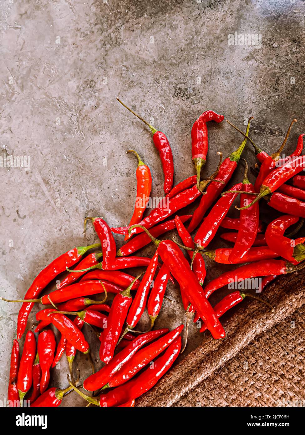 Piments rouges frais sur fond de tissu vintage. Piment rouge frais isolé. Banque D'Images