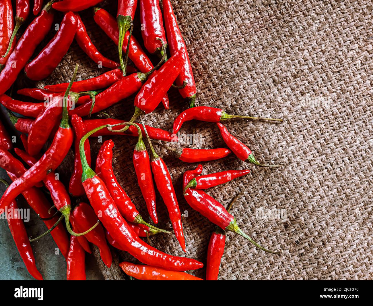 Piments rouges frais sur fond de tissu vintage. Piment rouge frais isolé. Banque D'Images