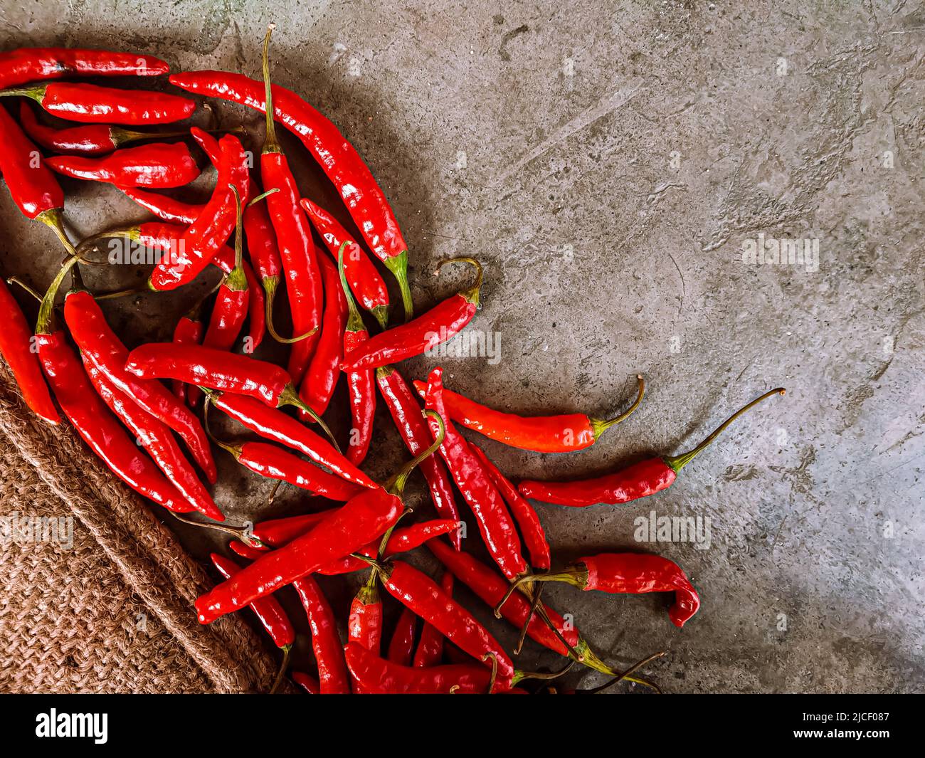 Piments rouges frais sur fond de tissu vintage. Piment rouge frais isolé. Banque D'Images