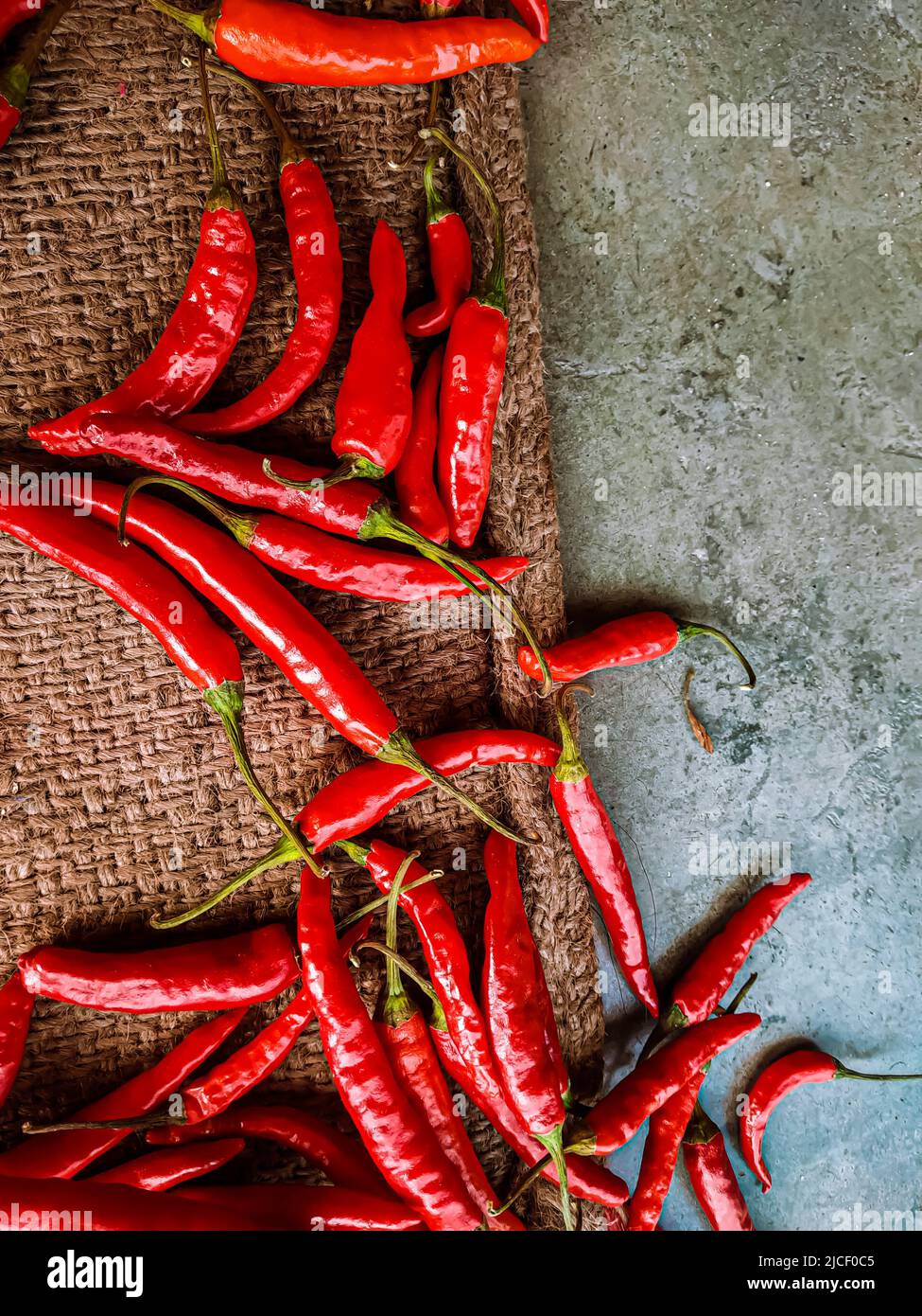 Piments rouges frais sur fond de tissu vintage. Piment rouge frais isolé. Banque D'Images