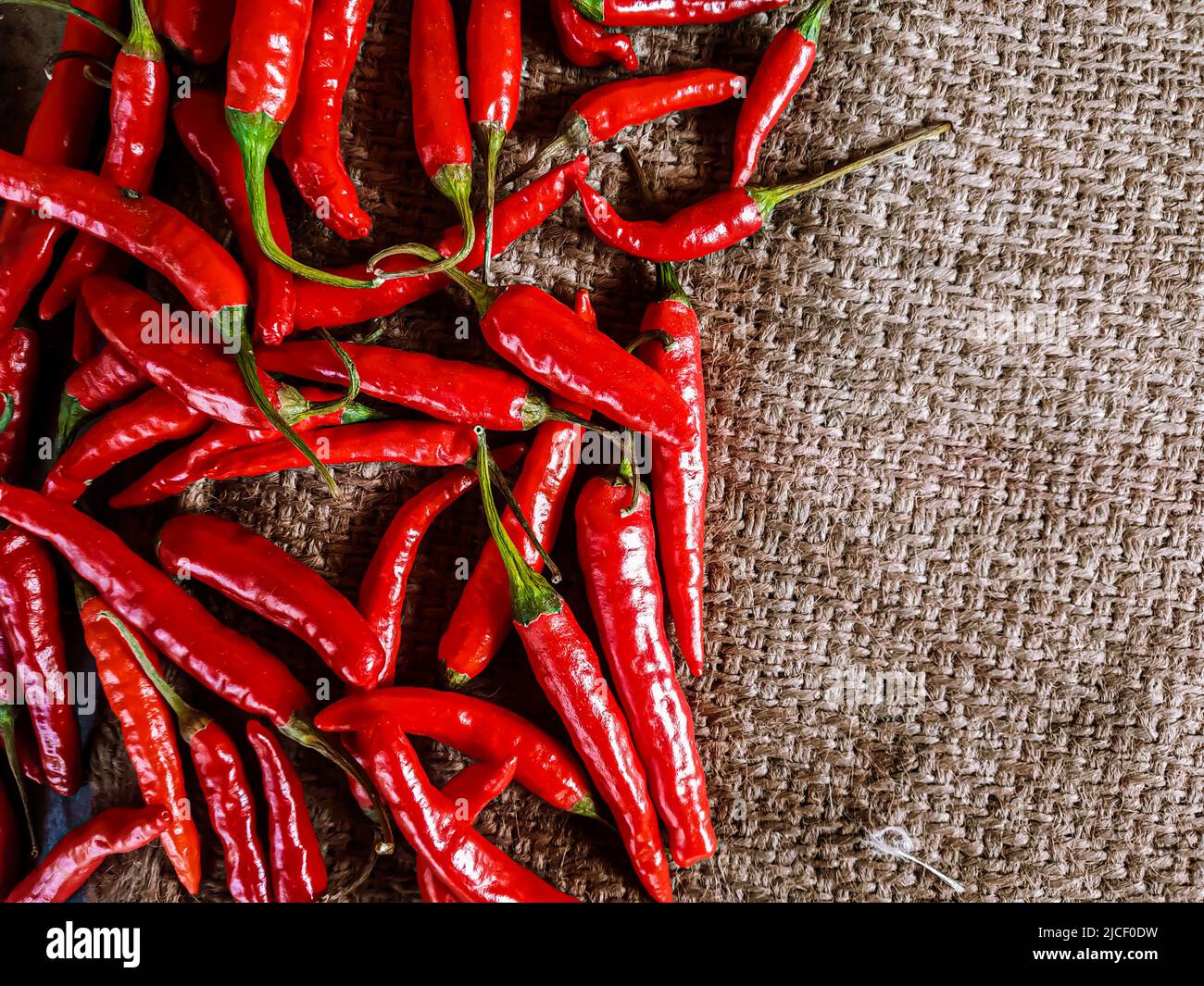 Piments rouges frais sur fond de tissu vintage. Piment rouge frais isolé. Banque D'Images