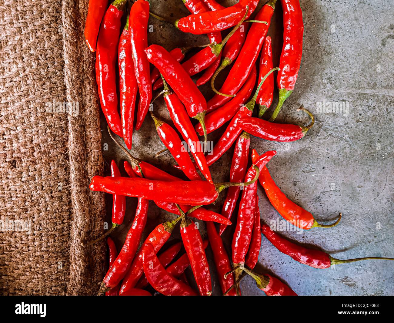 Piments rouges frais sur fond de tissu vintage. Piment rouge frais isolé. Banque D'Images