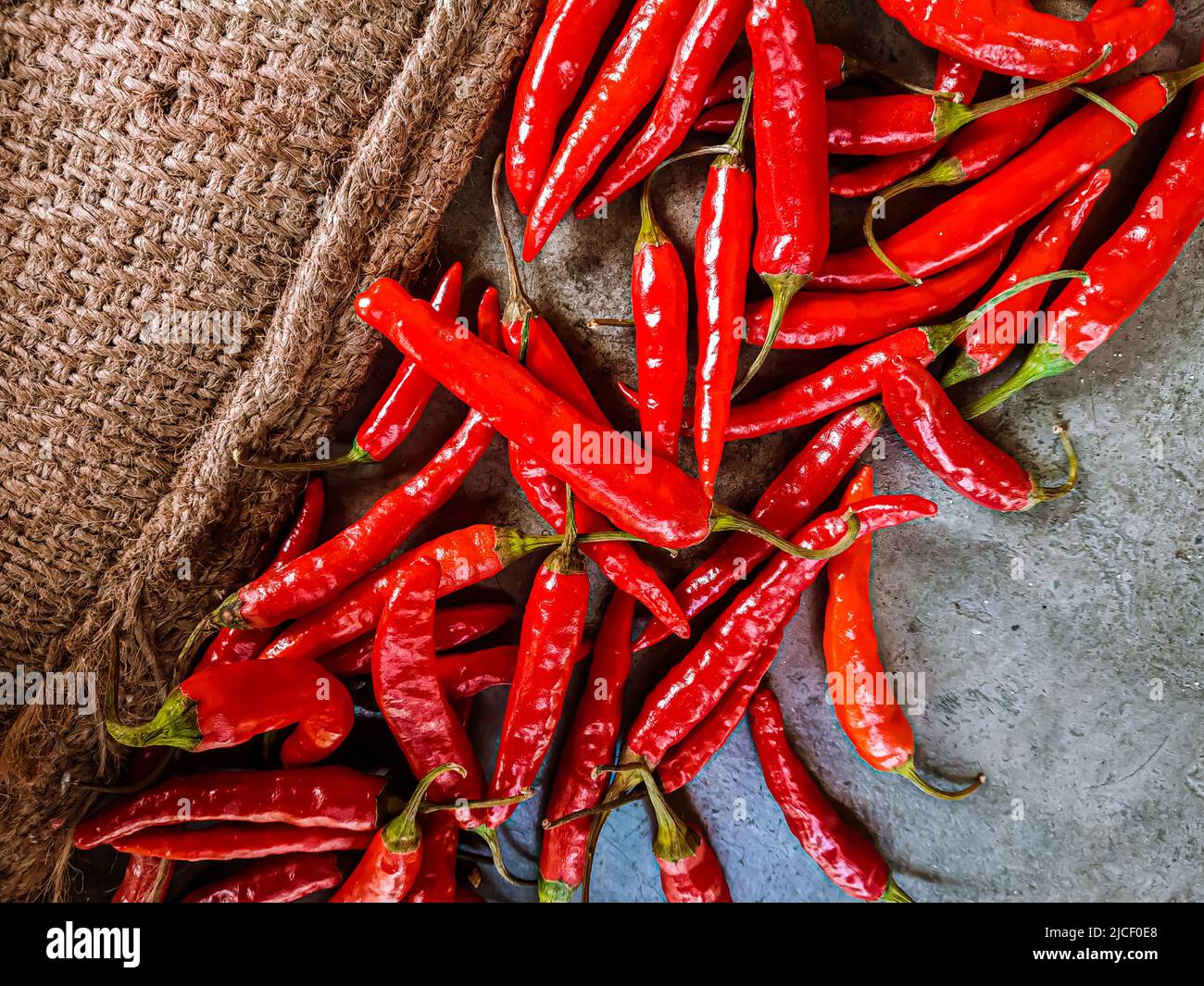 Piments rouges frais sur fond de tissu vintage. Piment rouge frais isolé. Banque D'Images