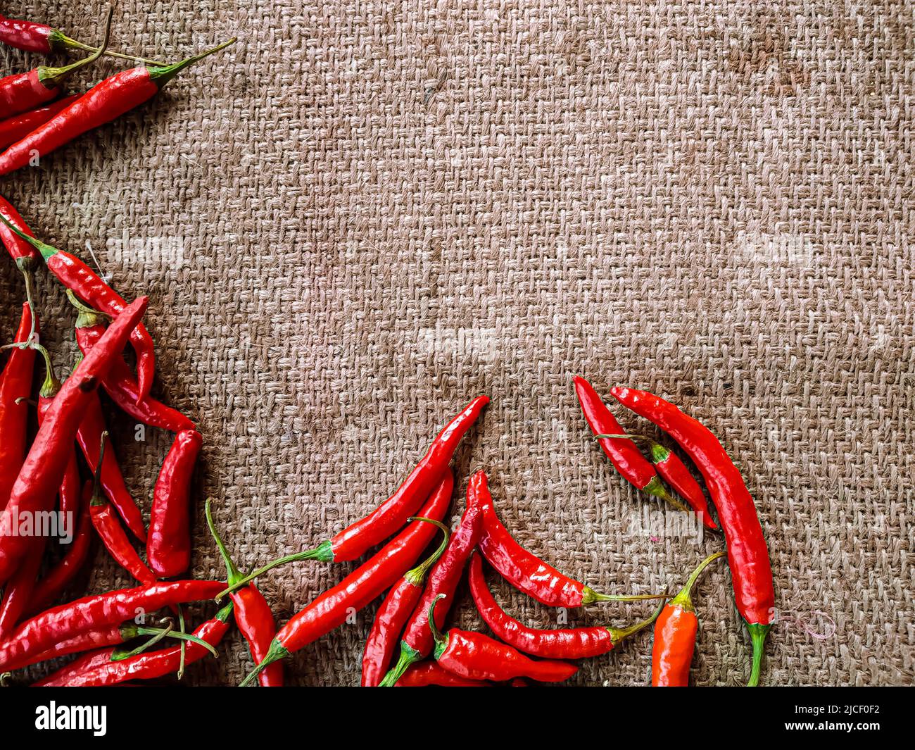 Piments rouges frais sur fond de tissu vintage. Piment rouge frais isolé. Banque D'Images