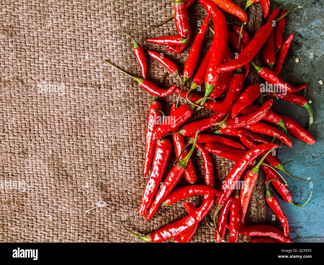 Piments rouges frais sur fond de tissu vintage. Piment rouge frais isolé. Banque D'Images