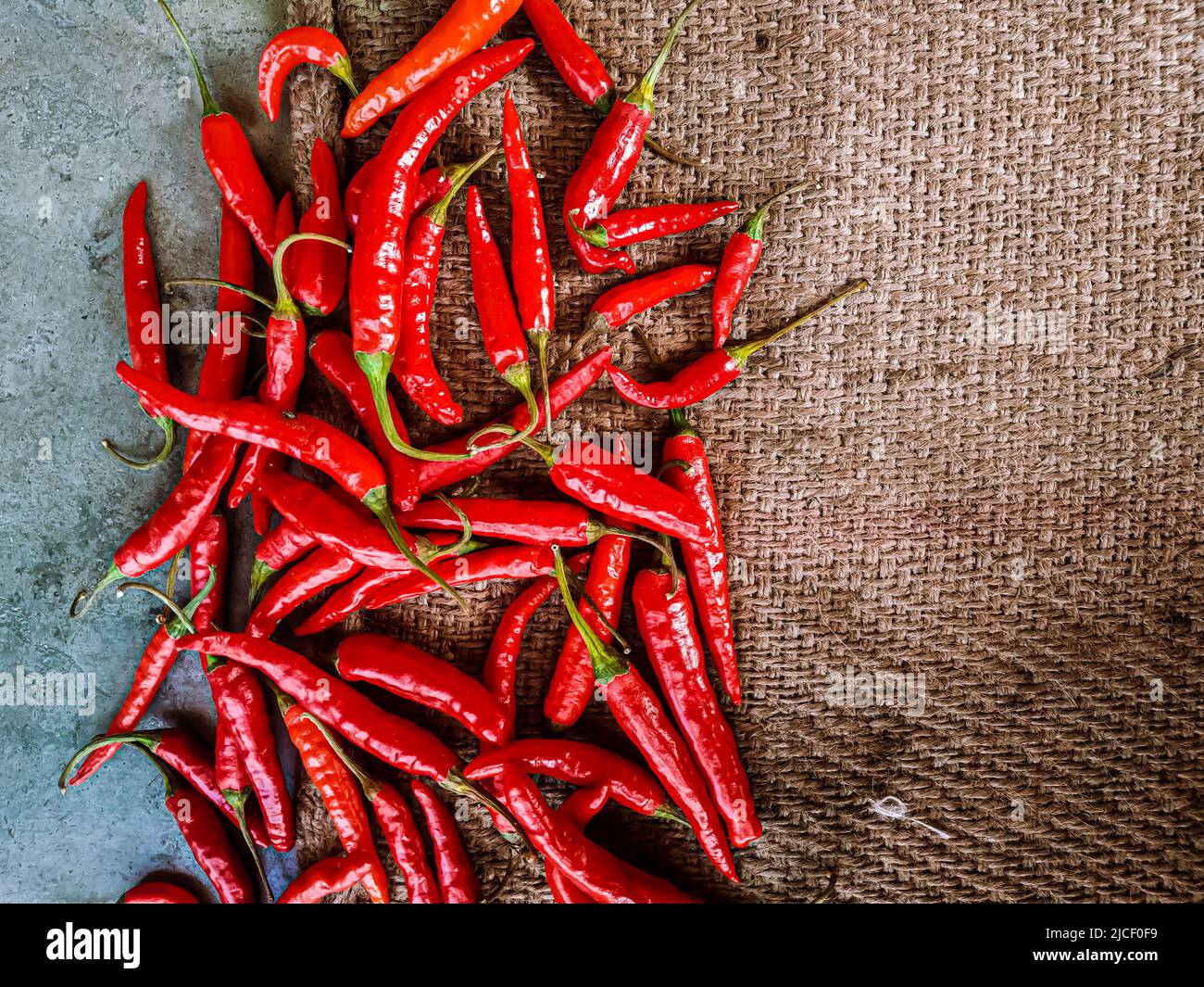 Piments rouges frais sur fond de tissu vintage. Piment rouge frais isolé. Banque D'Images