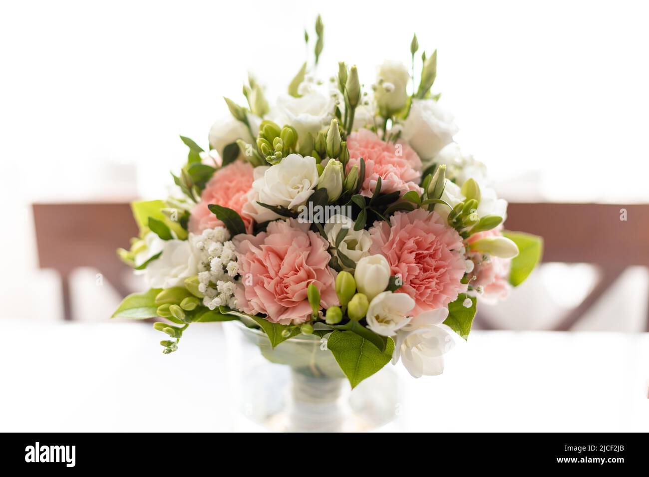 Rose frais, bouquet de fleurs de rose blanc dans vase transparent sur table avec imprimé nappe. Mariage, invitation de mariage Banque D'Images