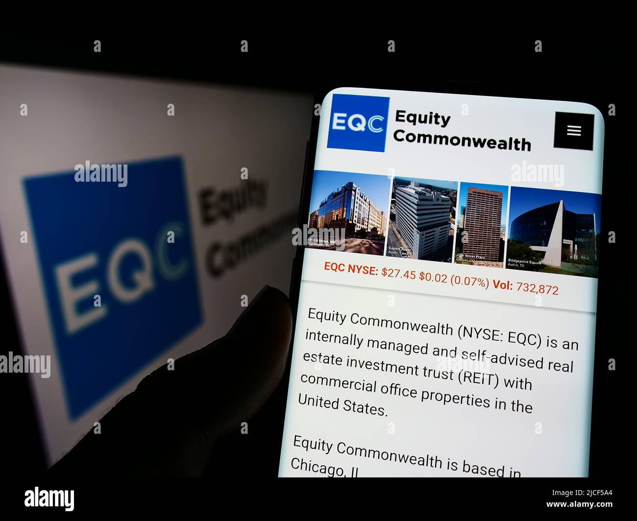 Personne tenant un téléphone portable avec le site Web de la société immobilière Equity Commonwealth (EQC) à l'écran avec logo. Concentrez-vous sur le centre de l'écran du téléphone. Banque D'Images