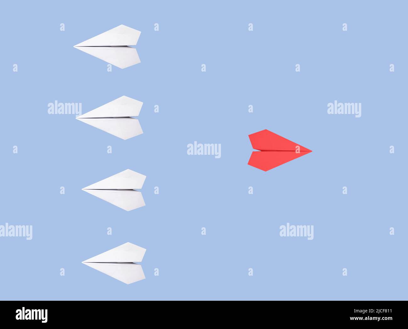 Des avions blancs à base d'origami avec un rouge exceptionnel volant dans la direction opposée sur fond bleu. Nouvelle idée, créativité, individualité, liberté, se démarquer du concept de foule. Photo de haute qualité Banque D'Images