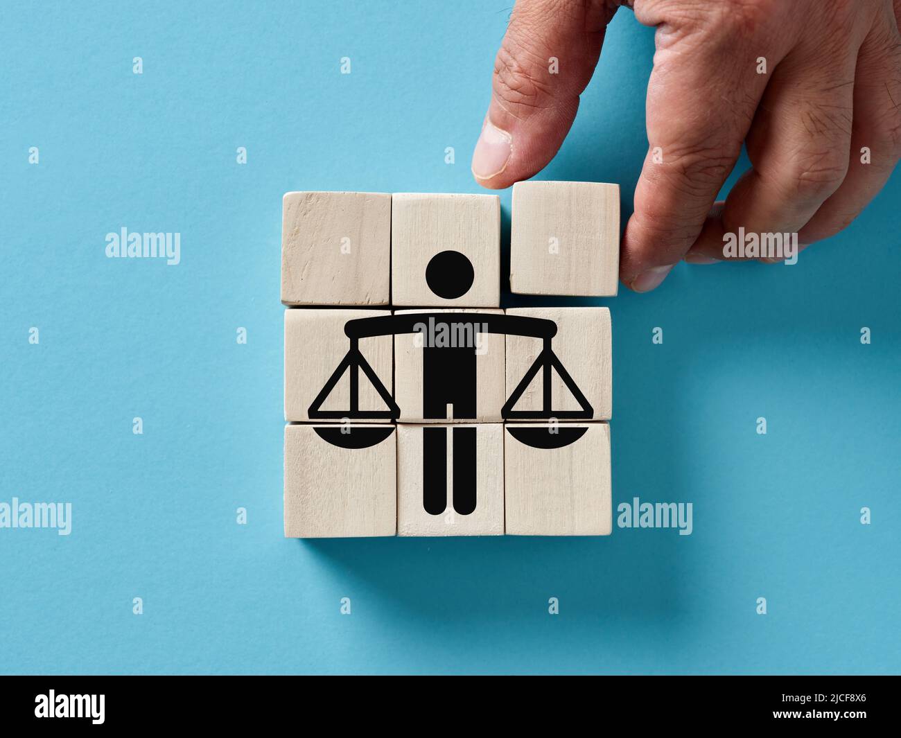 Main de sexe masculin organisant des cubes en bois avec l'icône de l'éthique des affaires ou de la justice. Les principes moraux, l'intégrité, la gestion équitable et le concept de justice. Banque D'Images