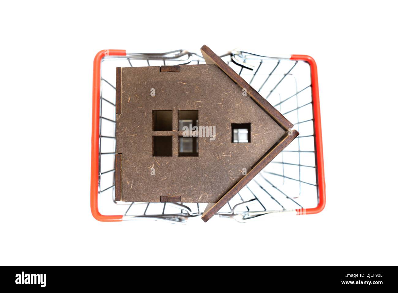 Vue de dessus d'un modèle de maison de jouets en bois dans un panier sur un fond neutre. Banque D'Images