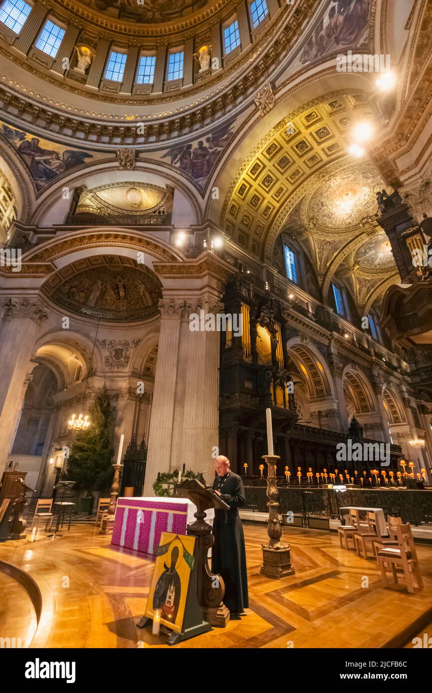 Angleterre, Londres, Cathédrale Saint-Paul, Priest offrant des prières matinales avec le Dôme et le Quire en arrière-plan Banque D'Images