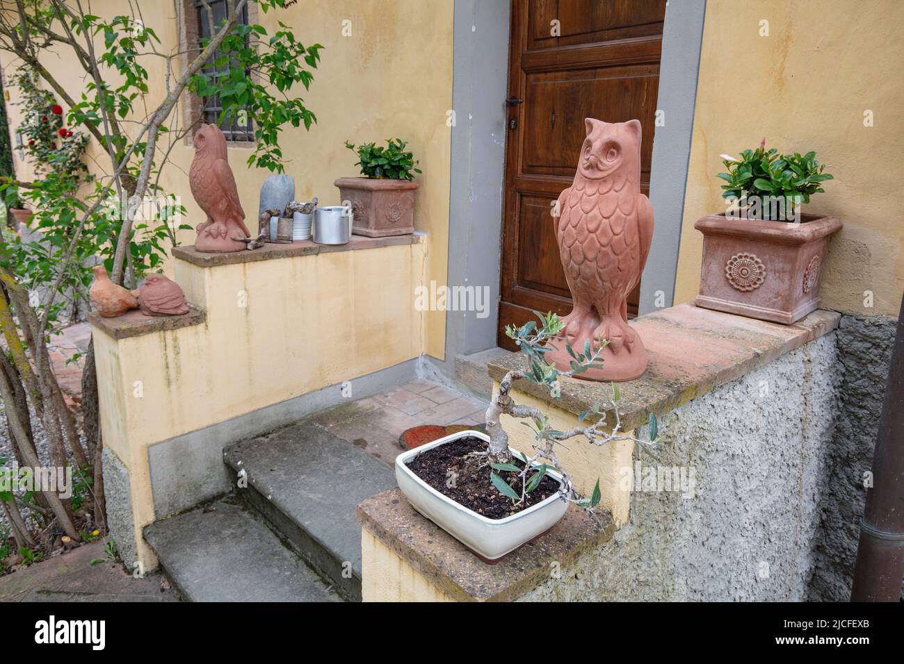 Italieb, Toscane, personnages en terre cuite devant une entrée de maison Banque D'Images