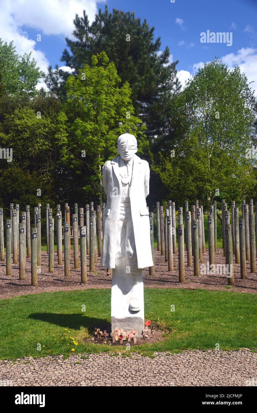 « Hot at Dawn » Figure en béton d'un jeune soldat bandié et des poteaux en bois à l'arboretum National Memorial, Lichfield, Staffordshire, Angleterre Banque D'Images