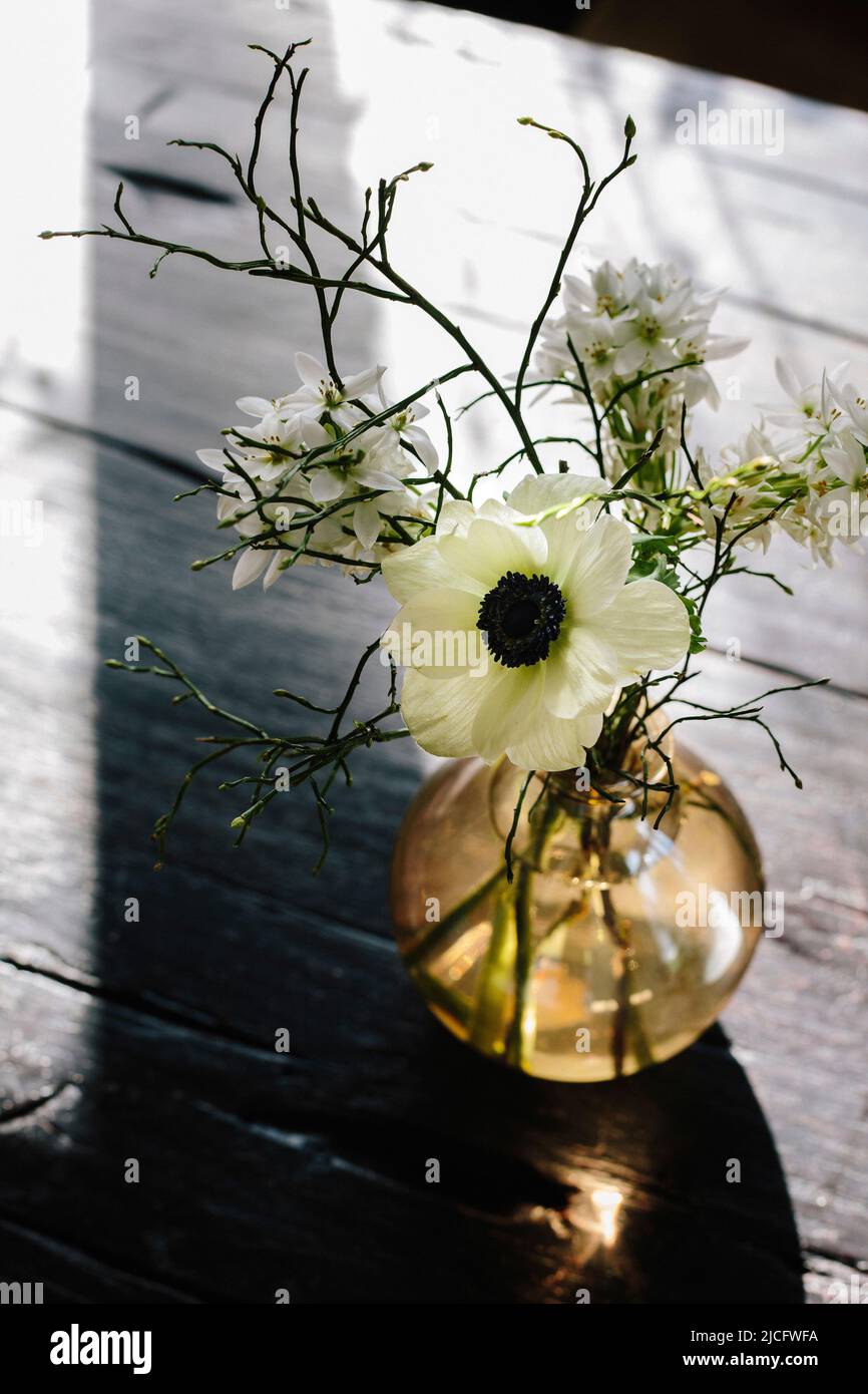 Vase en verre avec un bouquet de fleurs sur une table en bois Banque D'Images