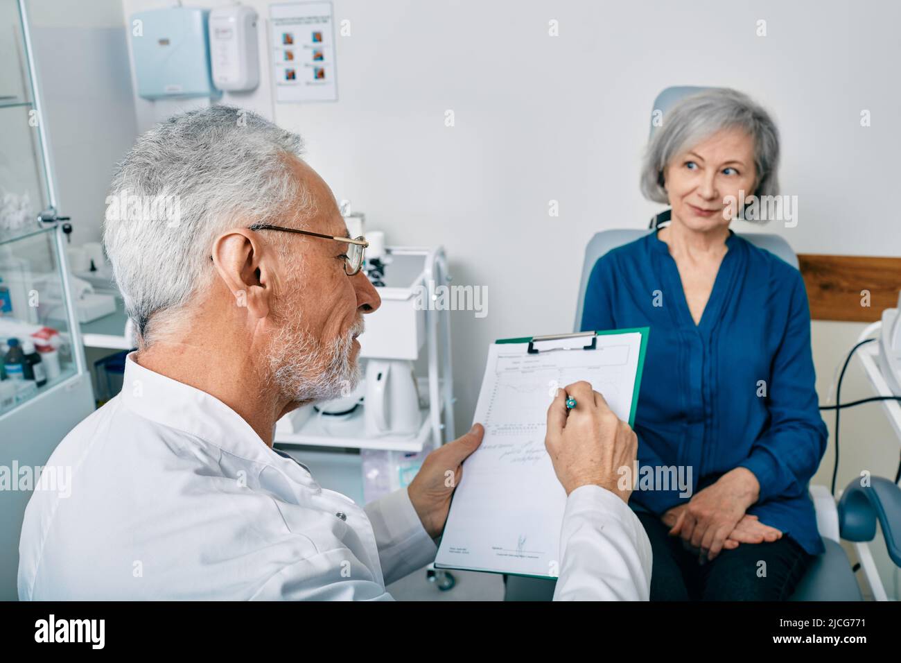 Audiologiste aux cheveux gris qui consulte une patiente âgée ayant des problèmes d'audition au centre auditif. Consultation du médecin de l'audition Banque D'Images