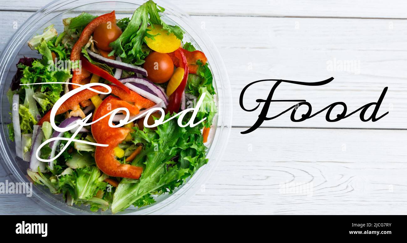 Image du texte de la bonne nourriture en noir et blanc, sur un bol de salade fraîche sur des planches de bois blanches Banque D'Images