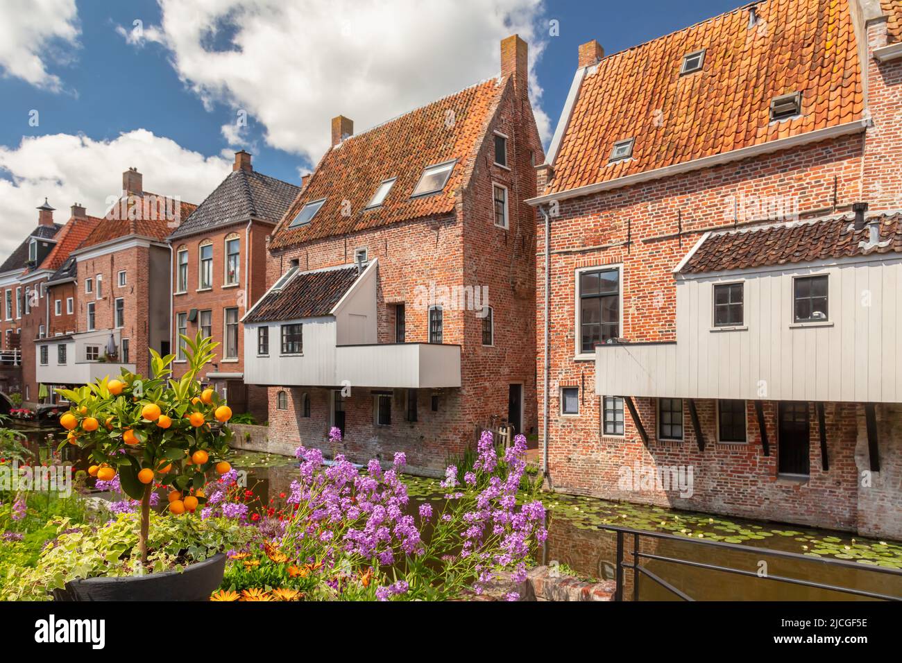 Vue d'été sur les maisons médiévales néerlandaises avec des cuisinettes suspendues au canal de Damsterdiep à Appingedam, Groningen, pays-Bas Banque D'Images