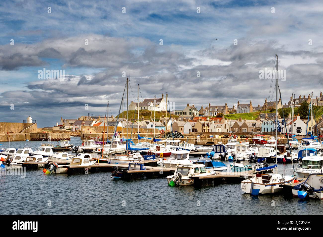 FINDOCHTY MORAY ÉCOSSE LE PORT AVEC DES BATEAUX AMARRÉS ET DES YACHTS ET L'ÉGLISE SUR LA COLLINE Banque D'Images