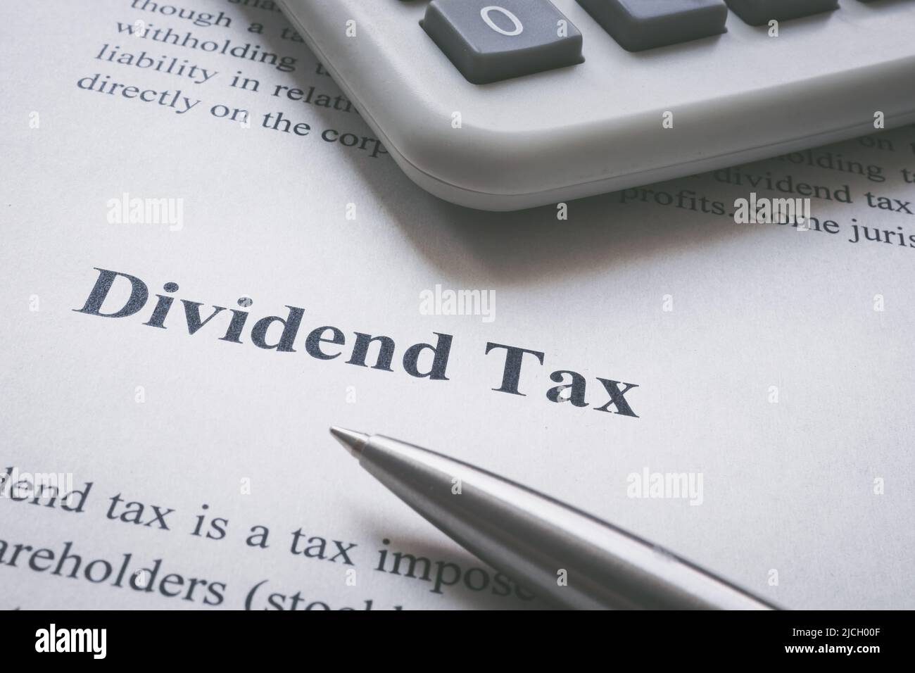 Page d'information sur l'impôt sur les dividendes, calculatrice et stylo. Banque D'Images