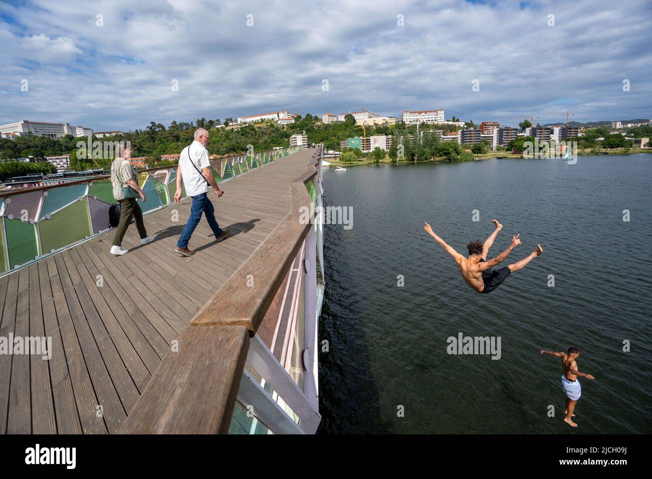 Jeunes hommes sautant sur le pont piétonnier Pedro e Inês au-dessus de la rivière Mondego à Coimbra, Portugal, Europe Banque D'Images