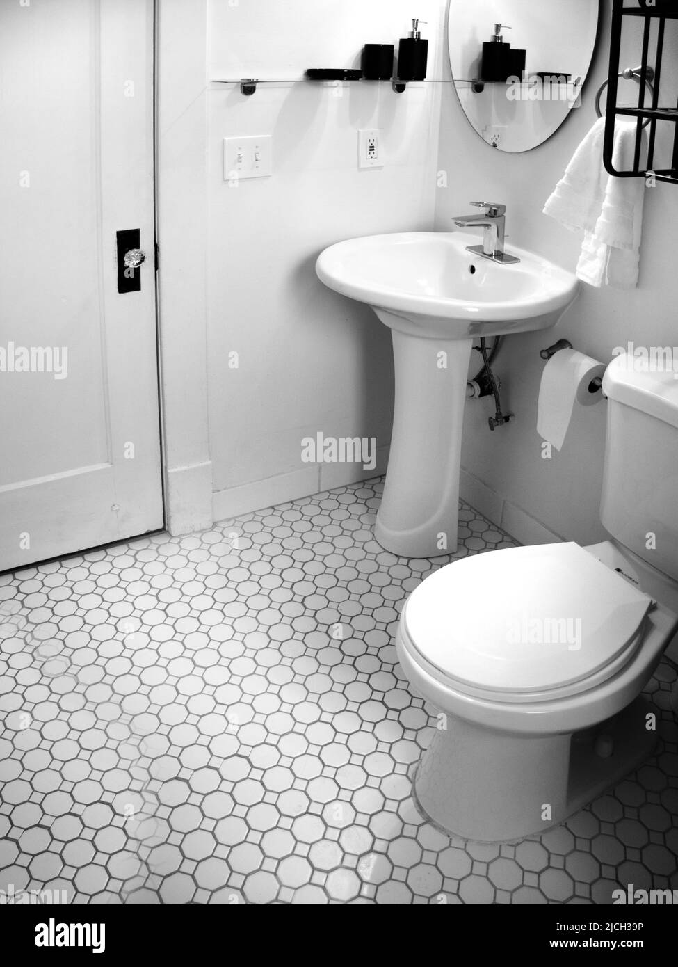 Salle de bains ancienne avec lavabo, carrelage blanc et miroir Banque D'Images