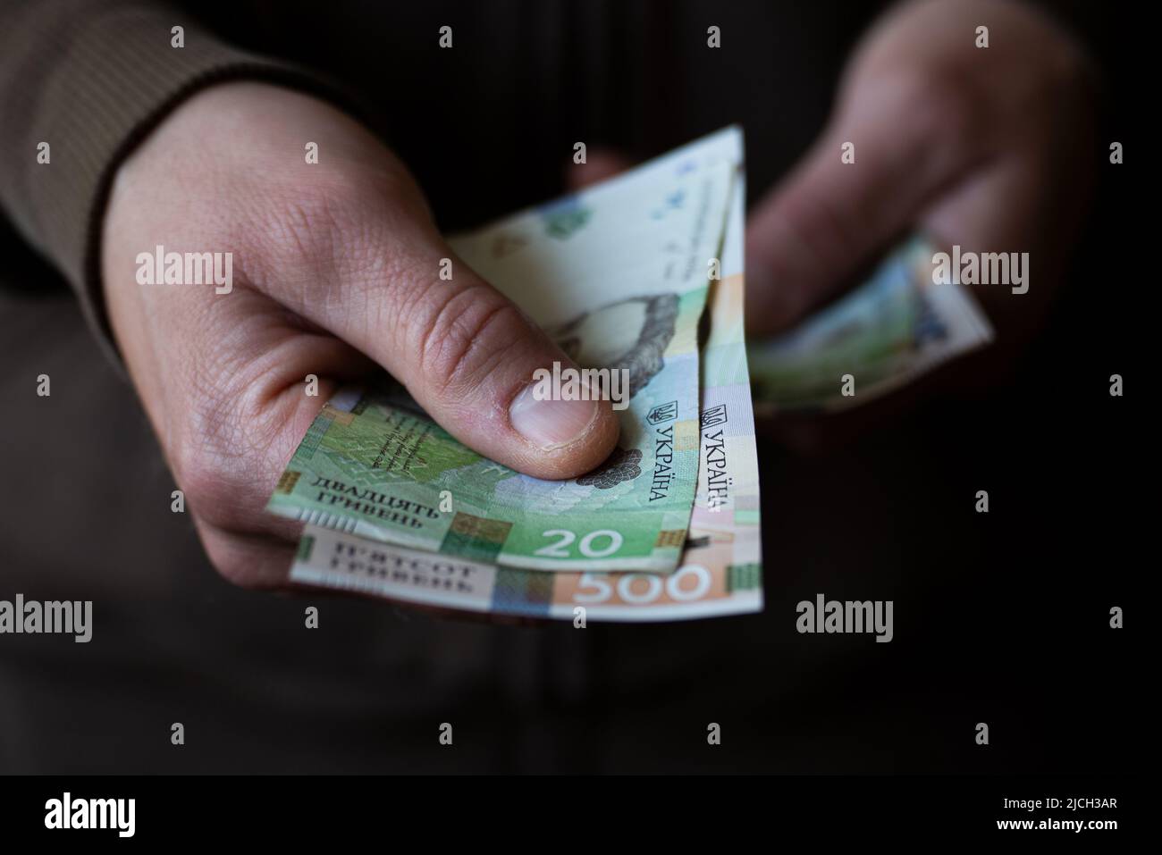 Un homme blanc qui donne des billets d'argent ukrainiens de près Banque D'Images