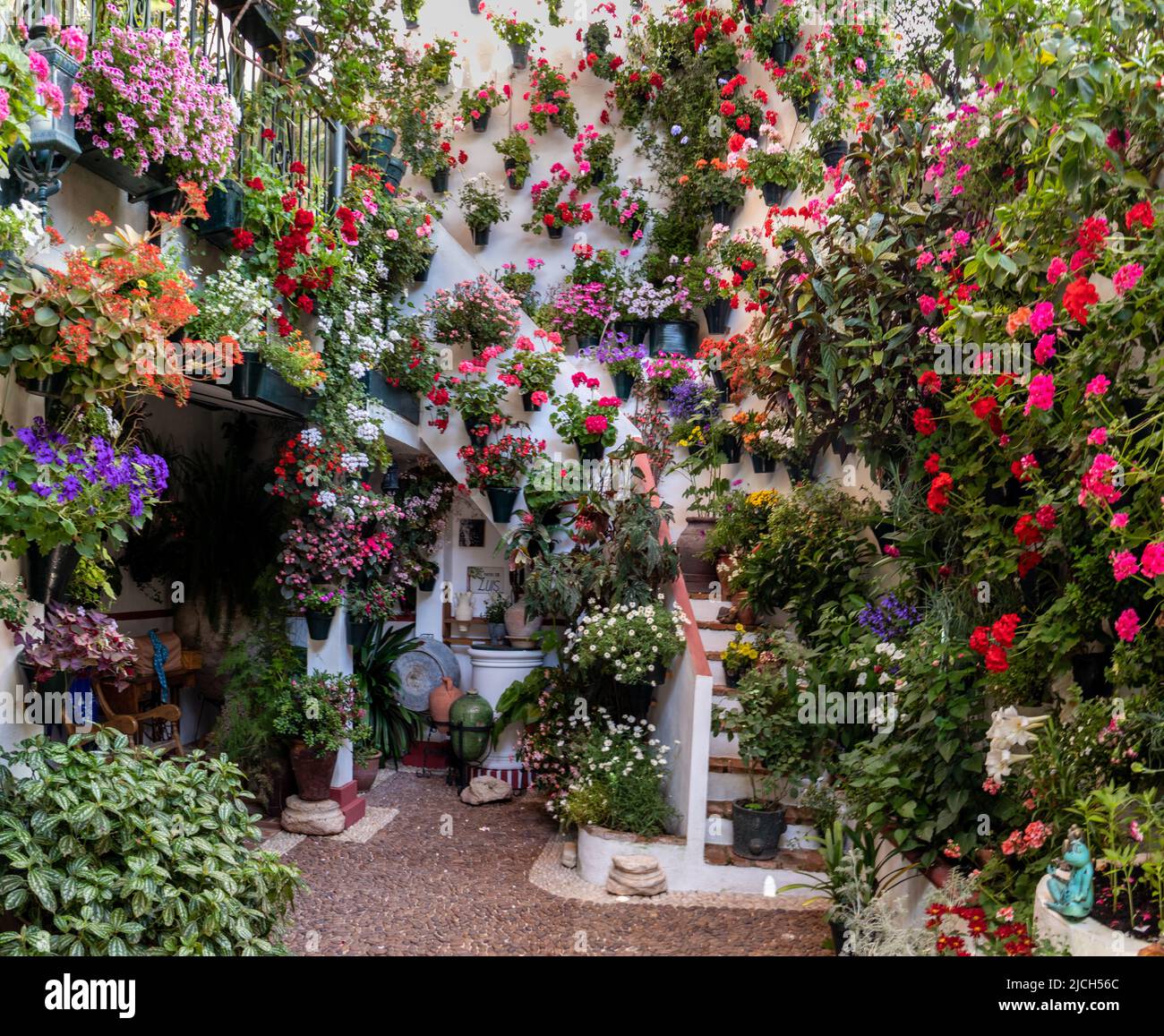 Patio con escamera, lleno de flores en primavera, Córdoba, España. Banque D'Images