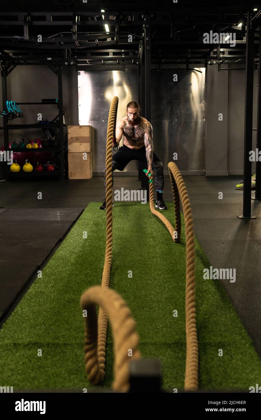 Corde entrepôt fitness homme vert herbe entraînement gym musculaire jeune, pour la force forte de l'activité physique saine, personne muscle. Croix Banque D'Images