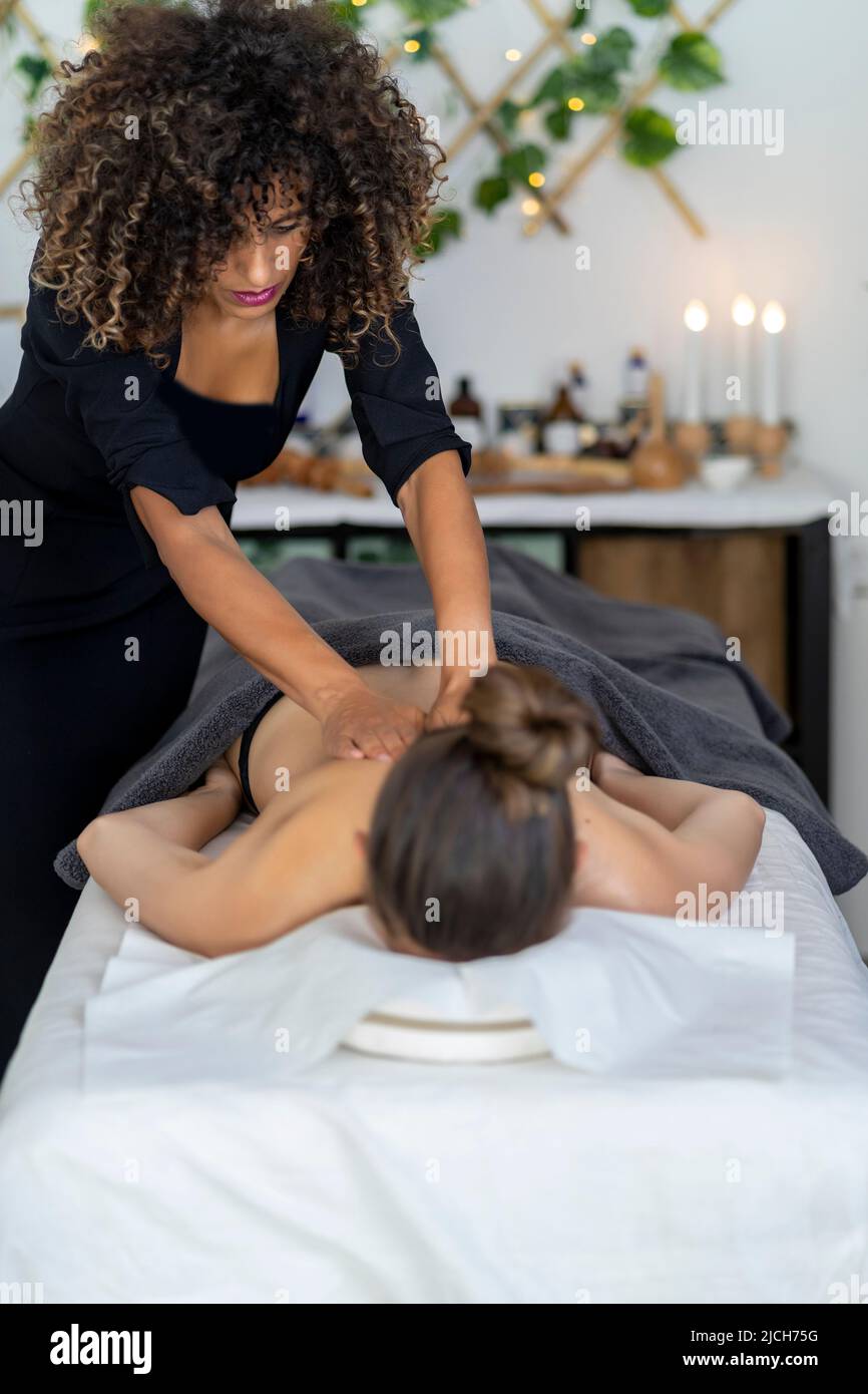 masseuse professionnelle effectuant un massage relaxant à son client Banque D'Images
