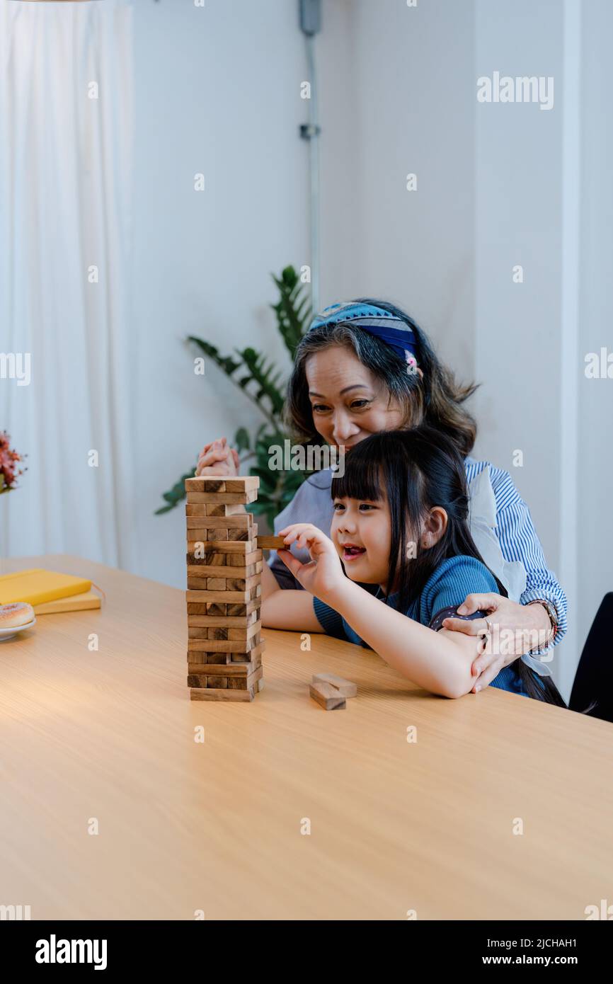 Portrait asiatique, petite-fille, petite-fille, grand-mère et petite-fille se joignent volontiers aux activités du jeu de bois de bloc Puzzle et d'améliorer les compétences Banque D'Images