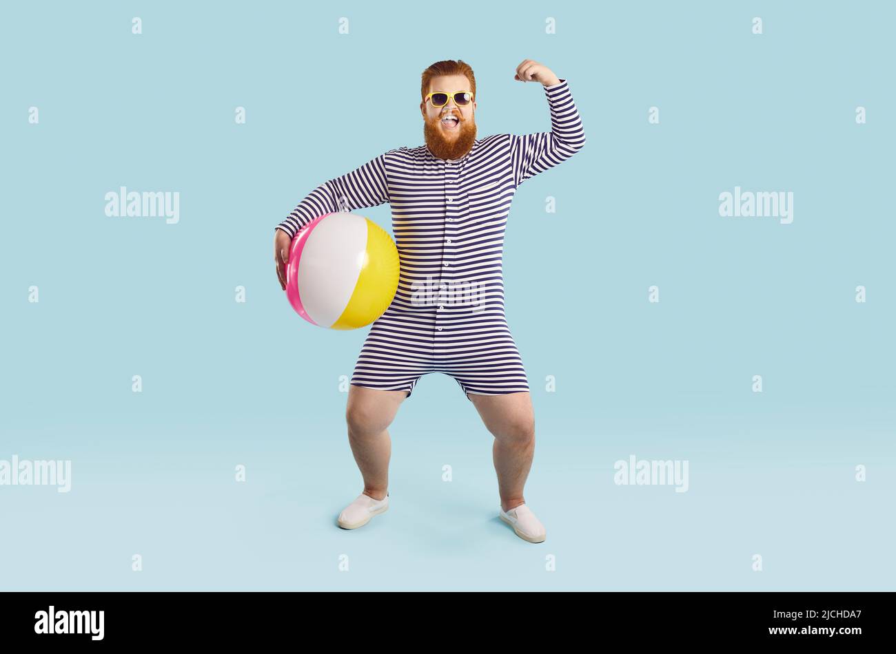 Gai drôle chubby homme avec ballon gonflable montre des muscles sur fond bleu clair. Banque D'Images