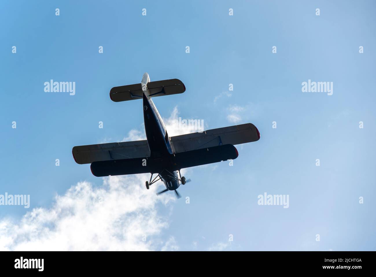 Petit biplan volant contre le ciel bleu Banque D'Images