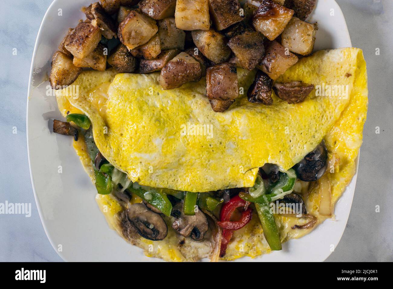 faire sauter l'oignon, les poivrons et l'omelette aux champignons avec des frites maison Banque D'Images