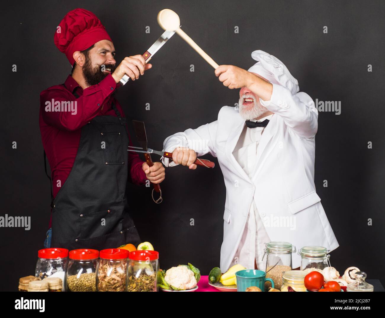 Deux chefs de restaurant ou boulangers en uniforme dans la cuisine. Cuisine. Concours de chef. Banque D'Images