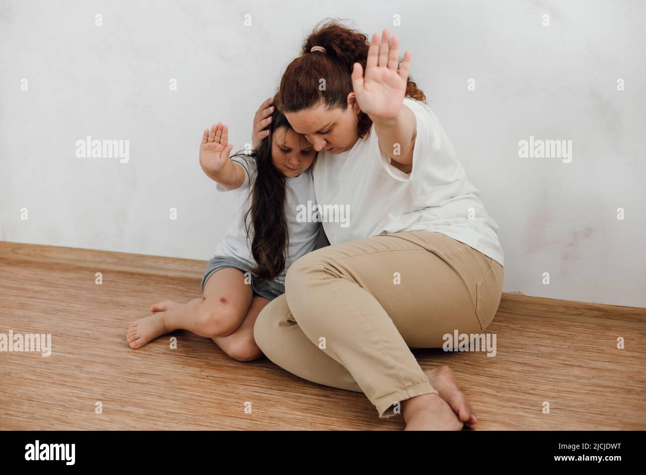 portrait de famille effroyée. Jeune mère peur femme embrassant petite fille, protégeant. Abus. Banque D'Images