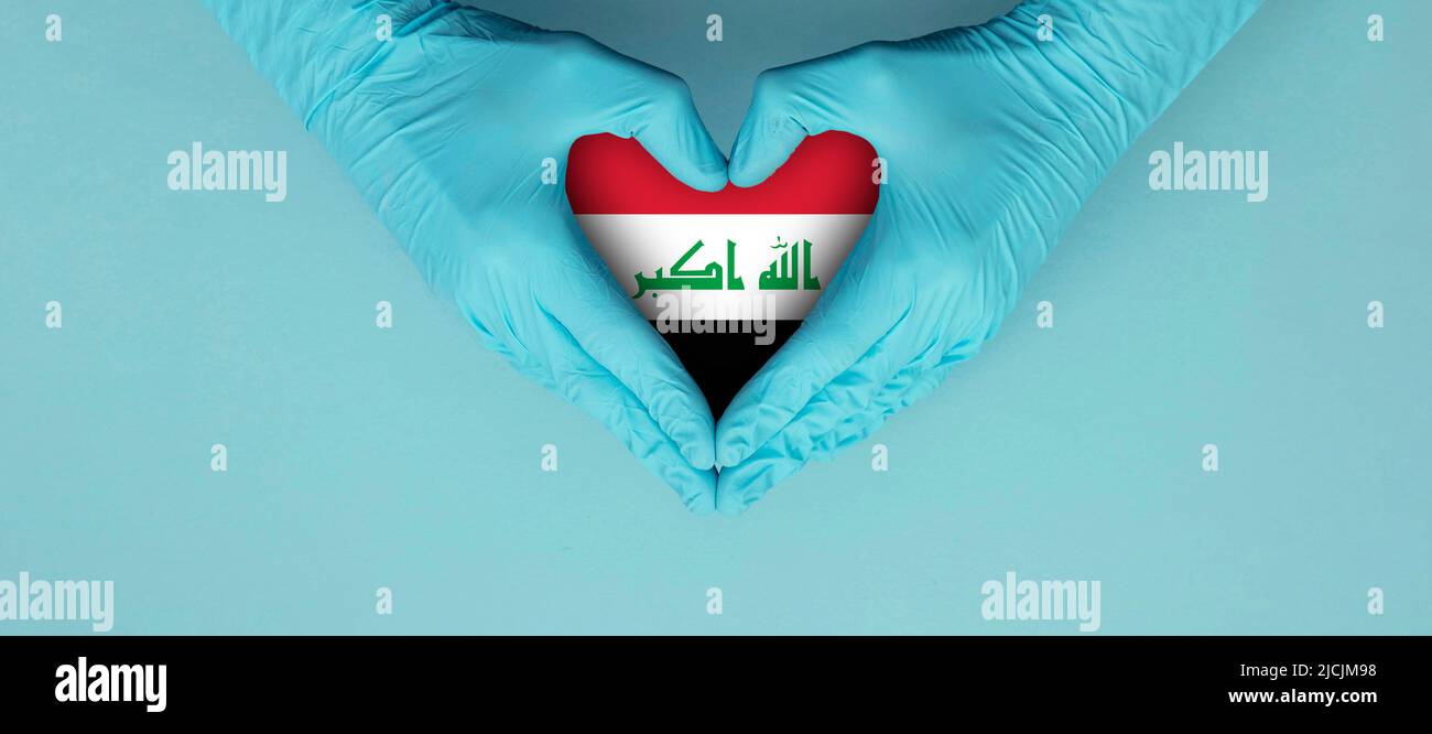 Les mains des médecins portant des gants chirurgicaux bleus faisant entendre le symbole de forme avec le drapeau de l'irak Banque D'Images